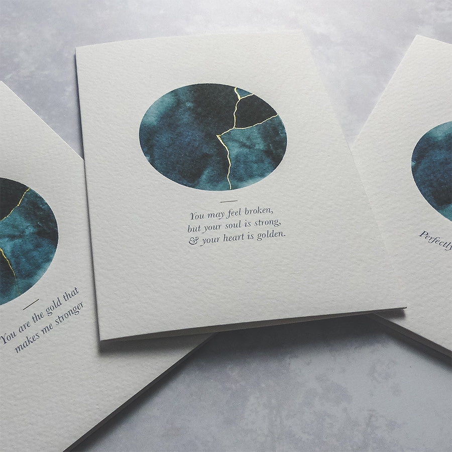 This A6 watercolour Kintsugi greeting card is printed at our studio & features an inky blue watercolour circle with hand-finished gold lines added.