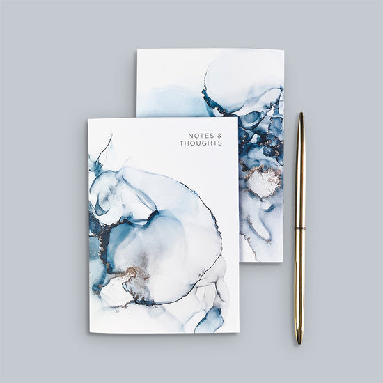 Load image into Gallery viewer, Stylish abstract A6 notebook featuring the design of one of our original alcohol ink prints from &amp;#39;The Ethereal Collection&amp;#39; in shades of blue &amp;amp; gold &amp;amp; pink.
