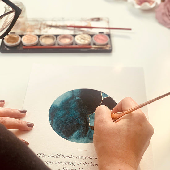 Load image into Gallery viewer, This A6 watercolour Kintsugi greeting card is printed at our studio &amp;amp; features an inky blue watercolour circle with hand-finished gold lines added.
